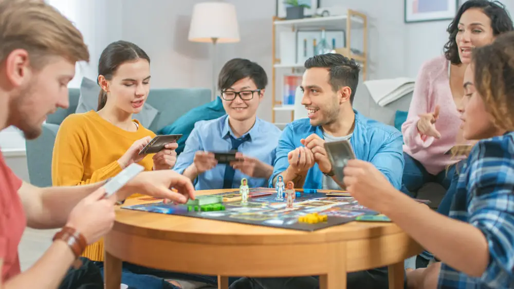 Group of people sitting around a table playing board games.