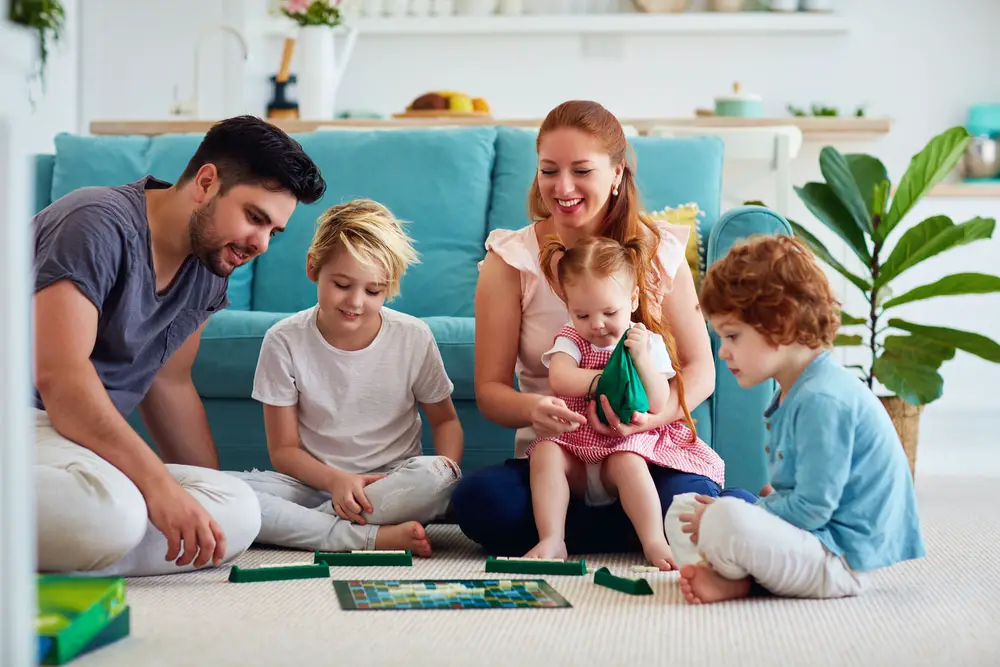 Kids and adults playing board games together.