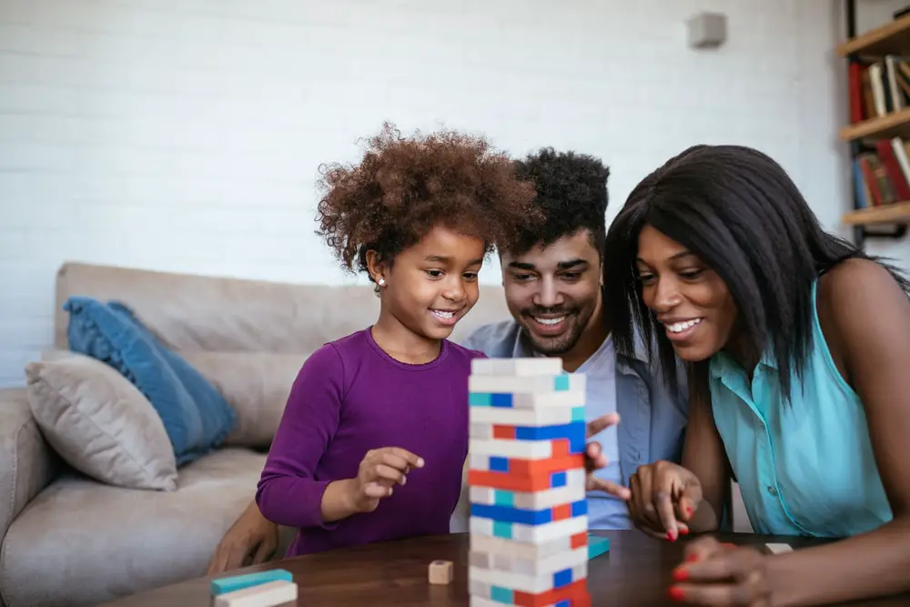 Parents playing board games with their kid.