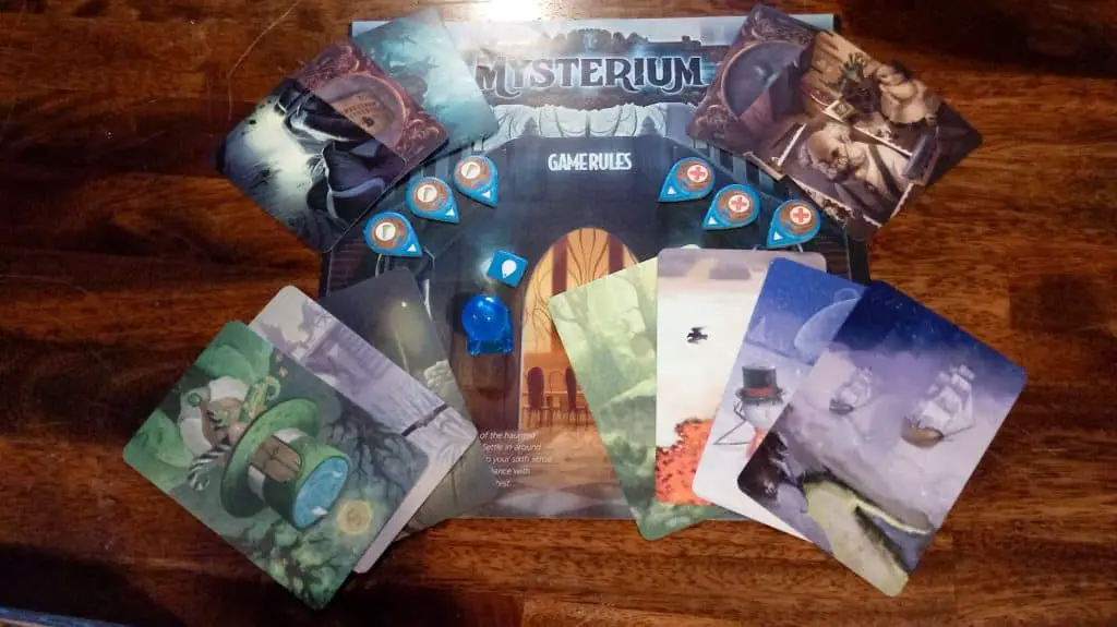 Closeup of the Mysterium rulebook and some components from the game. 