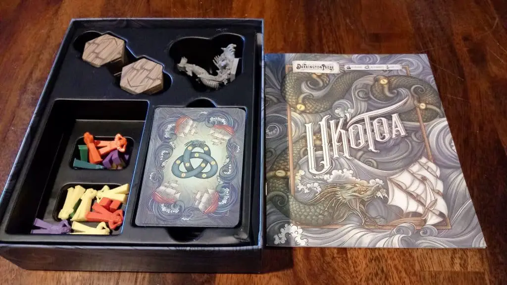 Closeup of the opened Uk'otoa box with rules cover and components showing.
