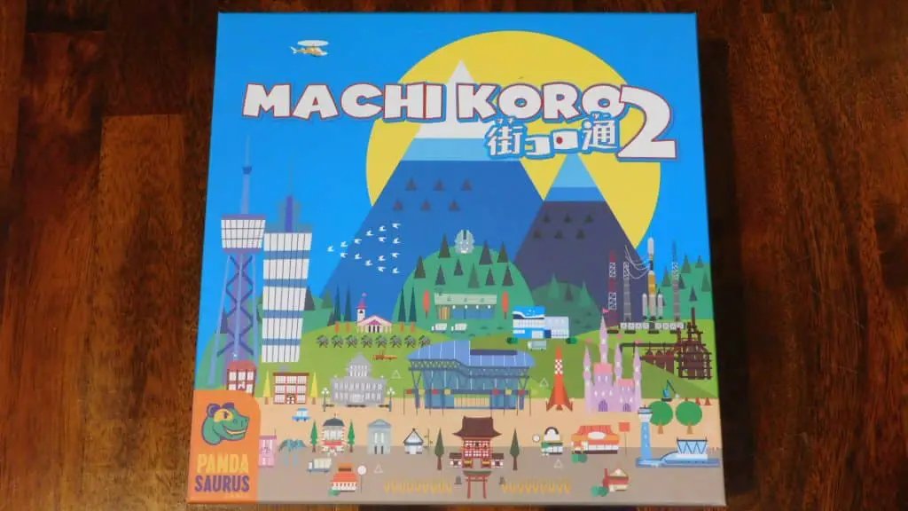 A closeup of the box cover for Machi Koro 2, which is another great choice when it comes to ideas for filler games.