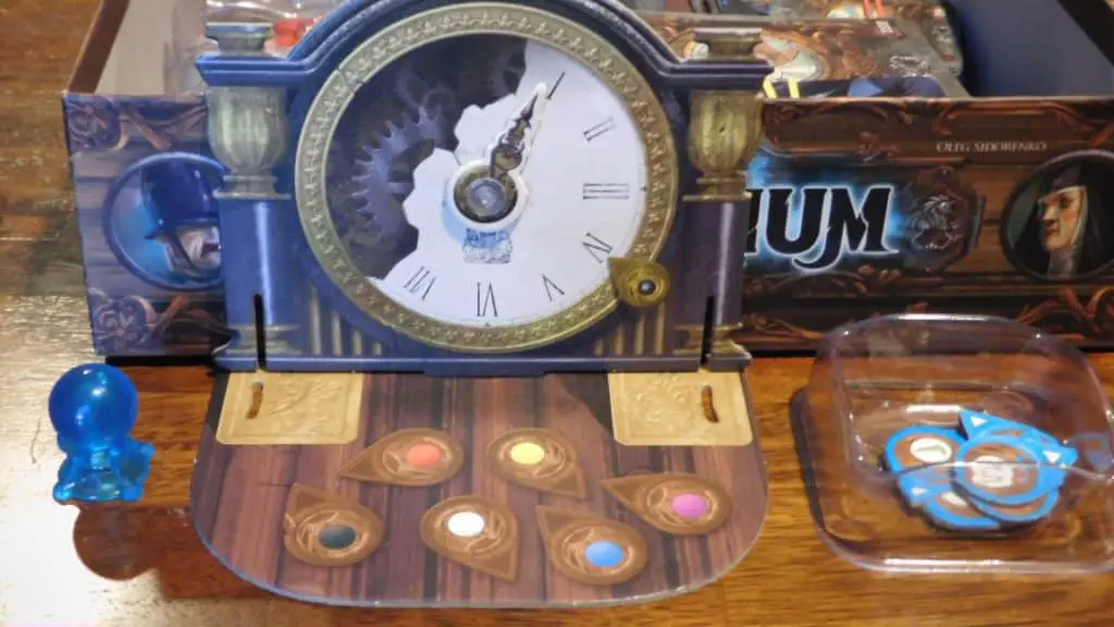 A closeup of some components of Mysterium and its game box.