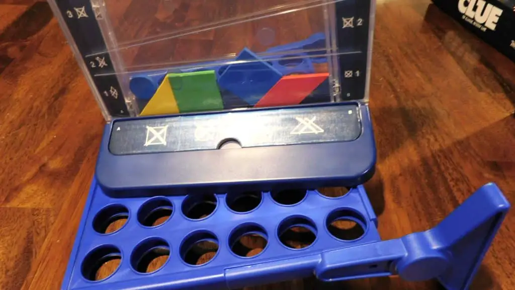 A game of Drop It in progress sitting on top of the grid for Connect 4, which is on its side.