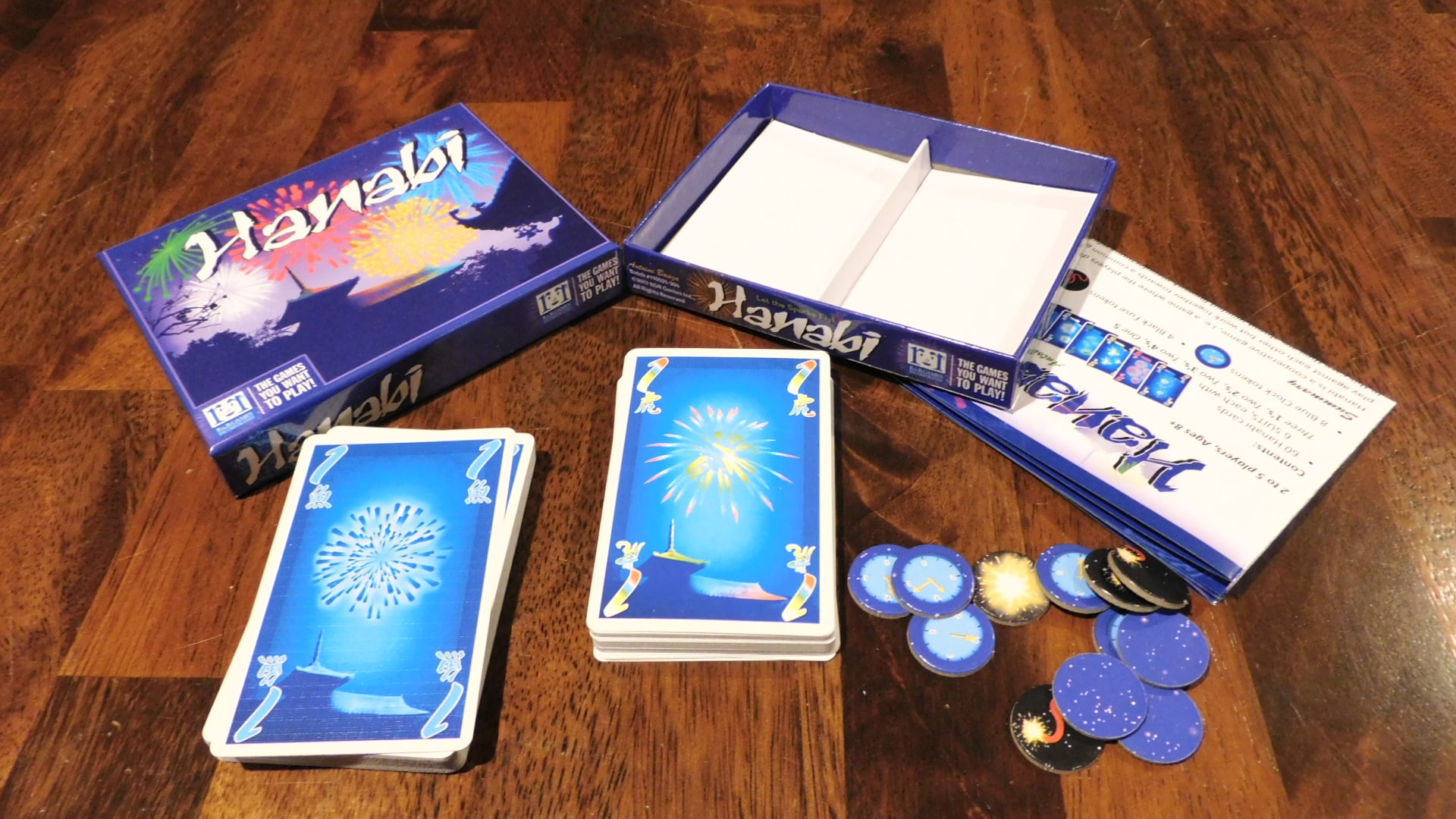An open box of Hanabi with all its components on the table.