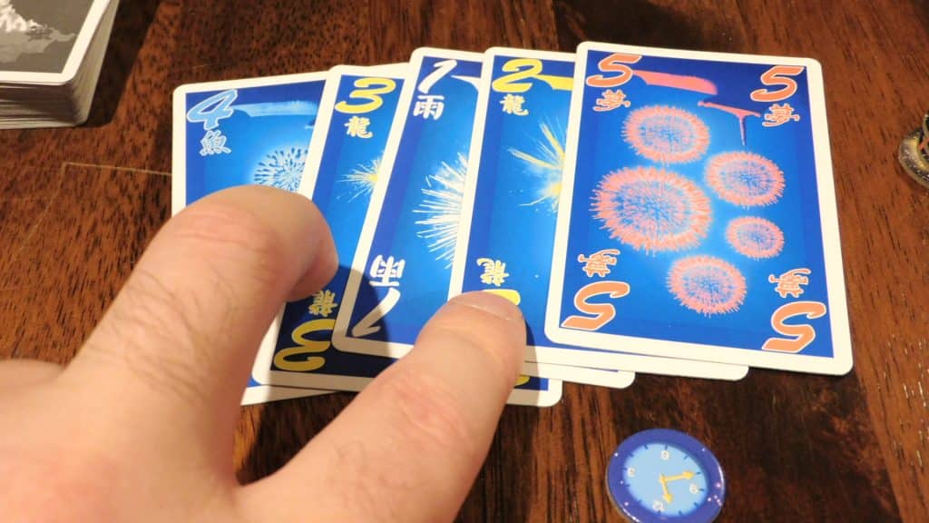 A hand point to some cards in Hanabi.