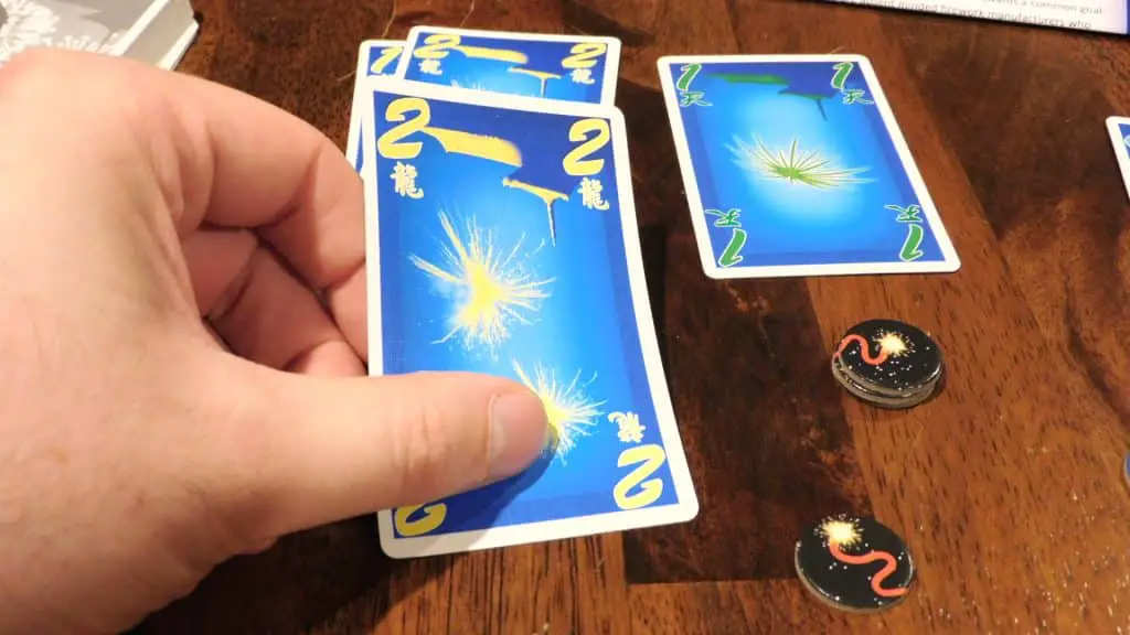 A hand playing a card in Hanabi.