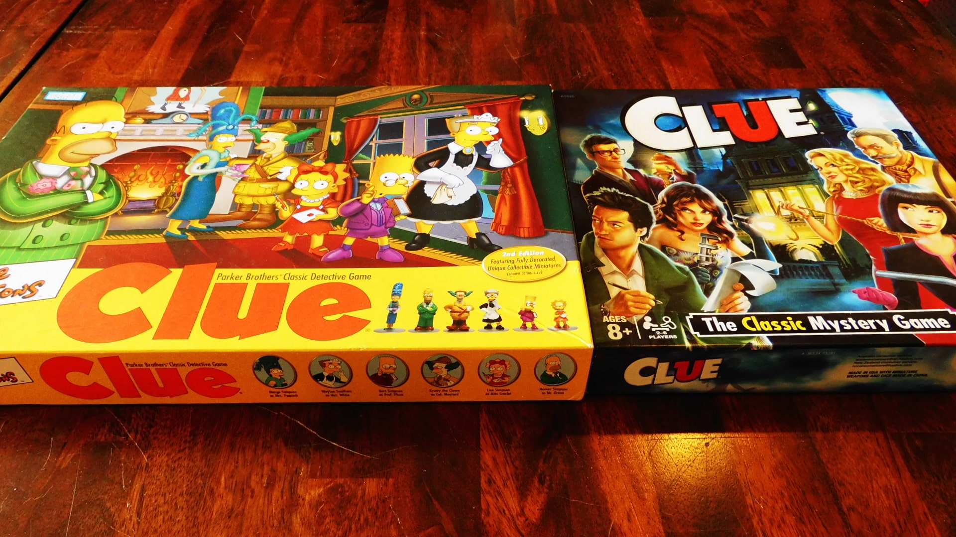 The box covers for Simpsons Clue 2nd Edition and Clue.