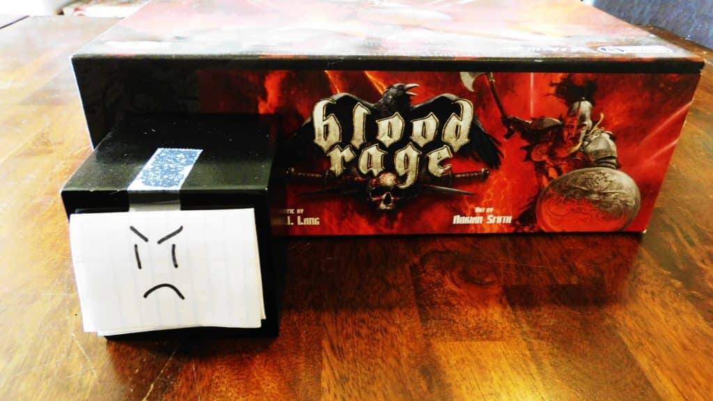 A closeup of Alpha Gamer Al and one side of the Blood Rage game box.