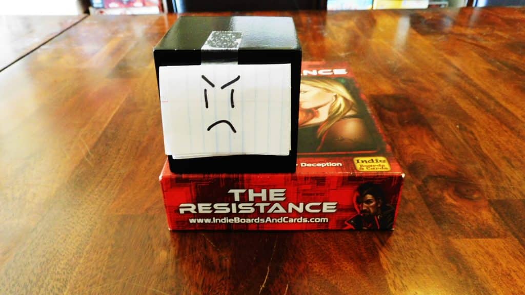 Alpha Gamer Al sitting on top of The Resistance game box.