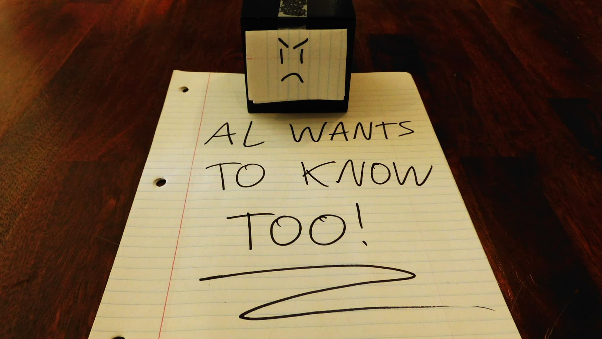 Alpha Gamer Al sitting on a piece of paper that says, "AL WANTS TO KNOW TOO!"