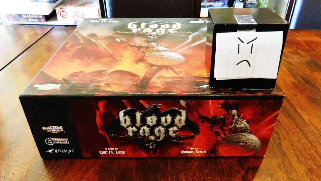 Alpha Gamer Al sitting on top of the Blood Rage board game box.