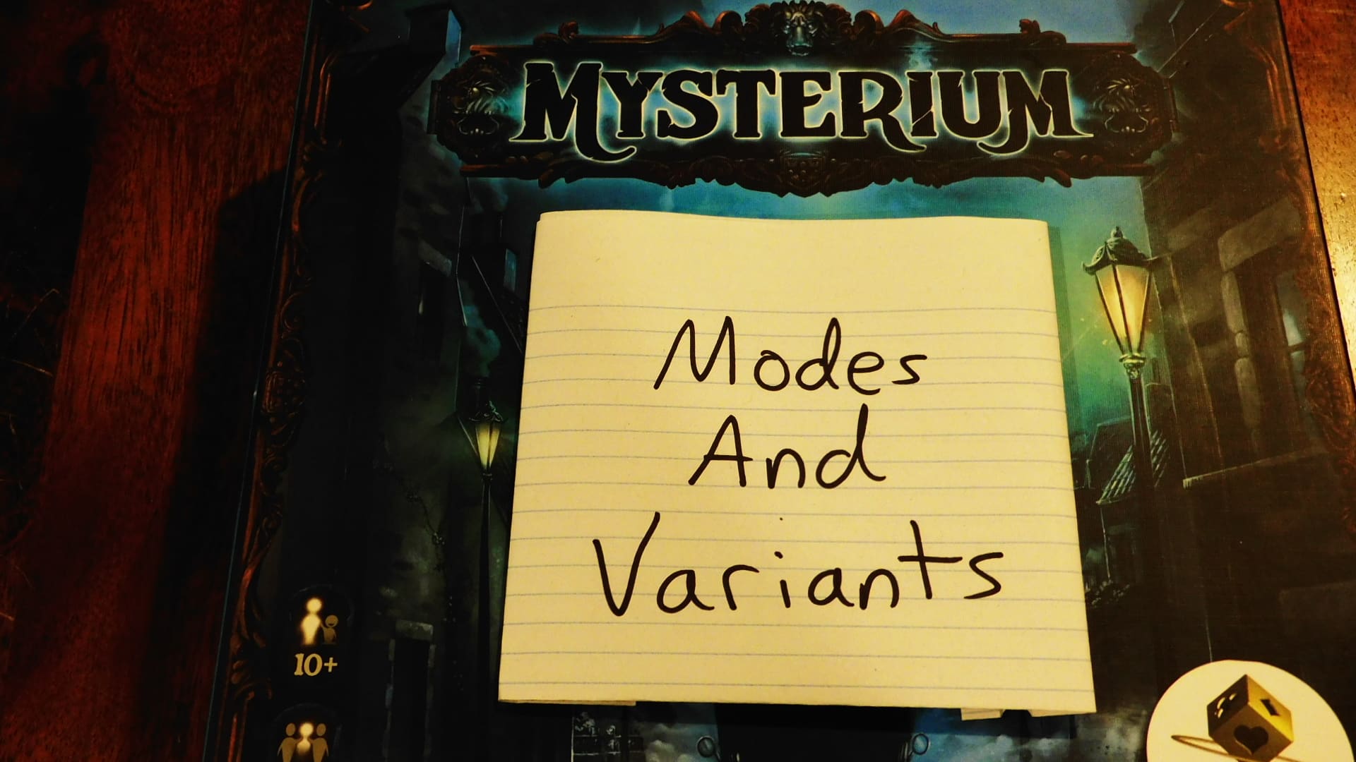 Mysterium's game box with a piece of paper on it reading "Modes And Variants."
