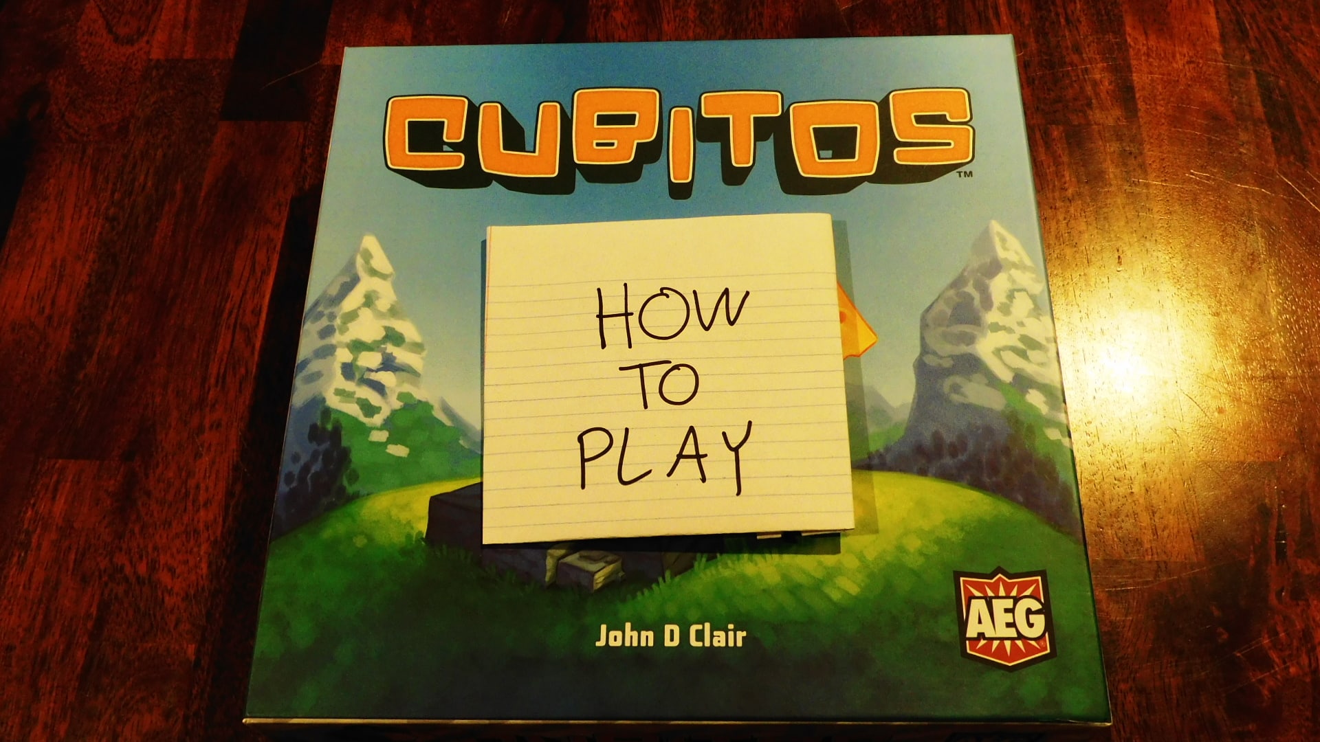 The Cubitos game box with a piece of paper on it reading "How To Play."